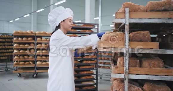 女面包师非常有吸引力的地方订购新鲜烘焙面包她穿着时尚的制服面包师视频的预览图
