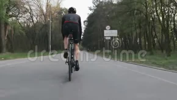 骑自行车的自行车骑自行车近距离观看腿部肌肉公园里骑自行车的人穿着黑色运动服视频的预览图