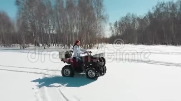 在雪地上驾驶ATV的女人男人骑在她身后视频的预览图