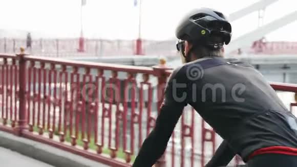 骑自行车的自行车背景是桥在城市公园骑公路自行车很容易后面跟着射击慢动作视频的预览图
