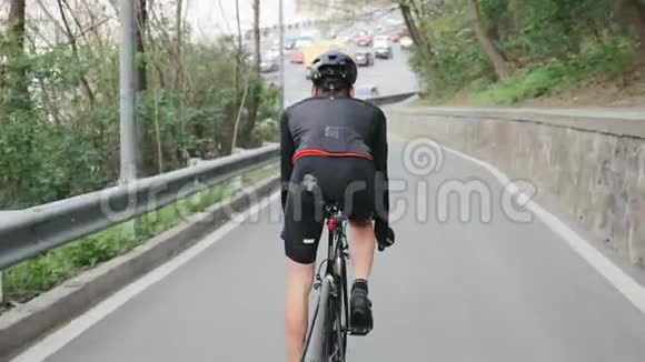 骑自行车的人穿着黑色运动服朝繁忙的城市道路走去自行车的概念视频的预览图