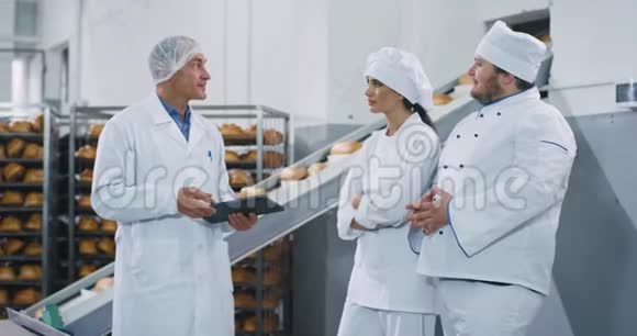 面包业自动输送机工程师向面包师讲解如何使用这台机器视频的预览图