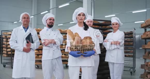 一家面包厂的主要团队长得很好他们手里拿着一个篮子里面放着新鲜的烘焙面包直视着镜头视频的预览图