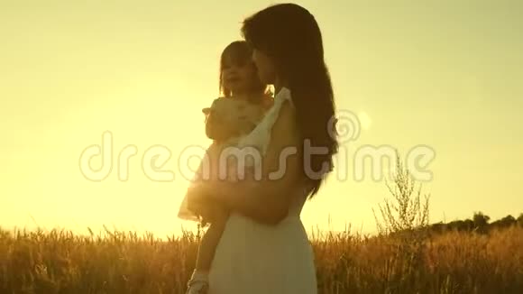 妈妈和小女儿正在一片成熟的麦子上玩耍母亲带着一个孩子在一片小麦的田野里散步开心快乐视频的预览图