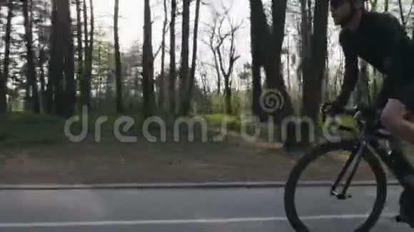 在公园的马鞍上骑着自信的自行车强壮的腿部肌肉旋转踏板自行车的概念慢动作视频的预览图
