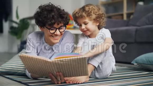 美丽的女人爱父母读书给小男孩说笑视频的预览图