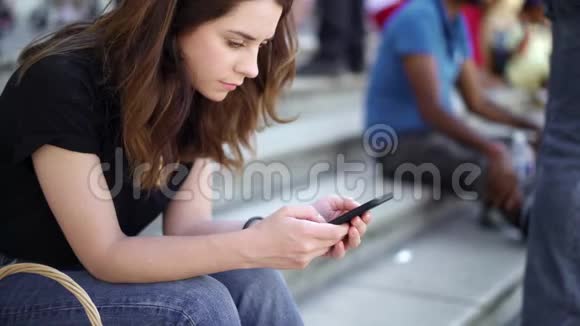 实时拍摄的女人与智能手机坐在楼梯在巴黎发短信视频的预览图