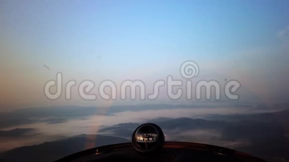 飞行在雾覆盖的景观上飞行员从小螺旋桨飞机驾驶舱的视角从中空中观看视频的预览图