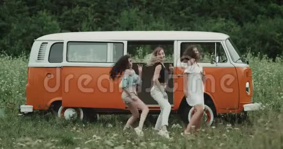 三个漂亮的女士在大自然中的复古货车前跳舞编舞4k视频的预览图