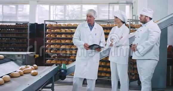 老人工程师向面包师厨师大个子解释使用自动输送线的规则并协助他视频的预览图