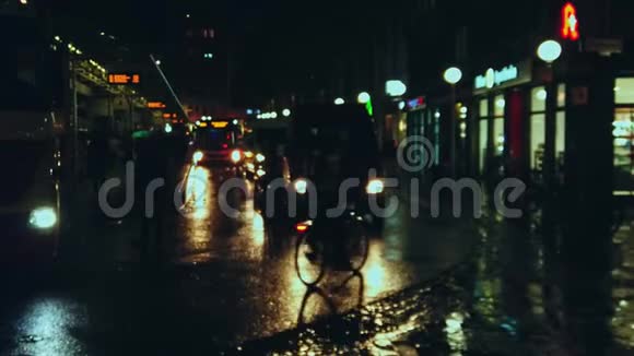 巴士站晚上有阵雨许多汽车行人骑自行车的人都在移动视频的预览图
