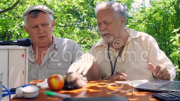 棕色桌子上苹果附近的老人宠物刺猬视频的预览图