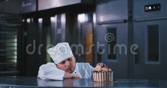 一个身材魁梧的面包师男人穿着厨师的服装看着这块不可抗拒的蛋糕一个长着胡须的哈士奇男人推着一个视频的预览图
