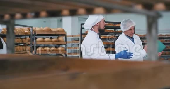 在一家面包厂年轻的面包师和老工程师有一个对话工程师给他一张说明书视频的预览图