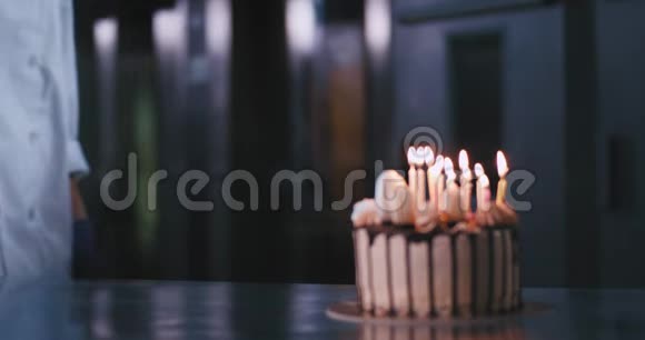 生日蛋糕里面有蜡烛在面包店的厨房里美丽迷人的女士面包师来到蛋糕前笑得很开心视频的预览图