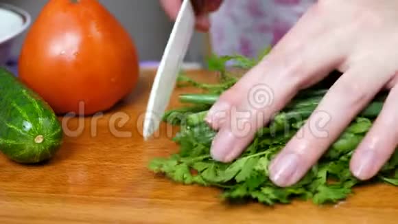 女性厨师切割洋葱和绿色欧芹视频的预览图
