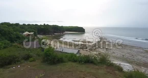 许多人走在靠近巴厘岛岩石海滩的海水中4K视频的预览图