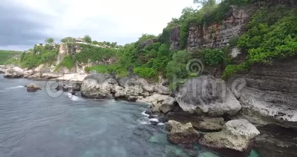 巴厘岛海岸上巨大的岩石覆盖着悬崖阴天4K视频的预览图