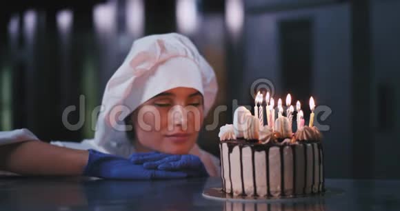 一位年轻的面包师女士戴着炊具帽用惊奇的目光盯着蛋糕视频的预览图