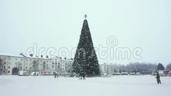 圣诞树在城市的中心广场上下午下雪城里的除夕夜冬季视频的预览图