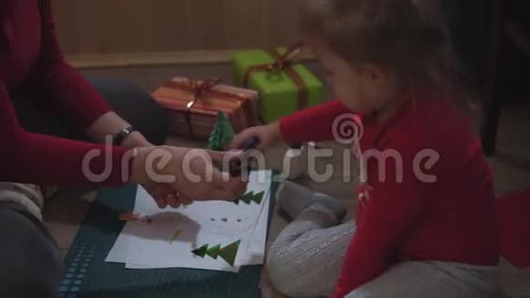 一个普通的计划妈妈和小女儿用纸贴花堆雪人视频的预览图