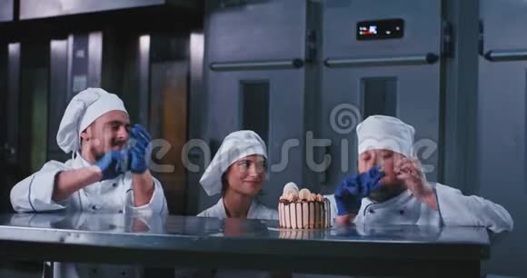 一位优雅的女士和两位穿着厨师服装的面包师男士在这个迷人的生日上开始挑选时都很兴奋视频的预览图