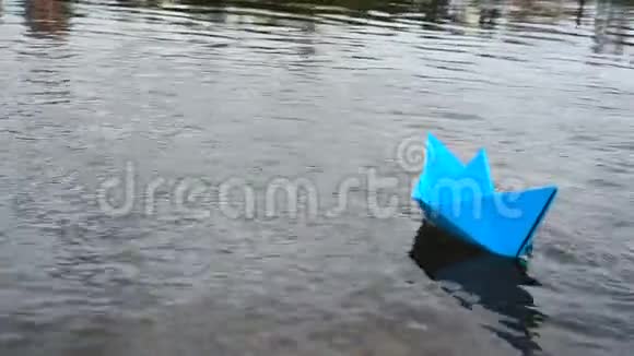 蓝色纸船在浪漫的夕阳下在水上航行折纸视频的预览图