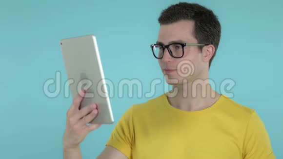 年轻人通过蓝底平板电脑进行视频聊天视频的预览图