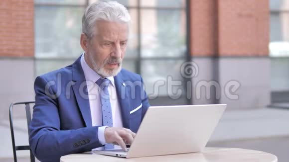 老商人在笔记本电脑户外庆祝成功视频的预览图