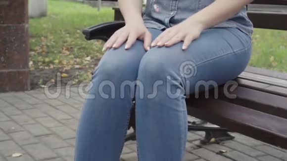 不可辨认的女人在公园的长椅上等人视频的预览图