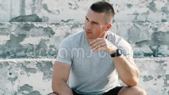 有魅力的肌肉运动员坐在训练前的肖像强壮的外表视频的预览图