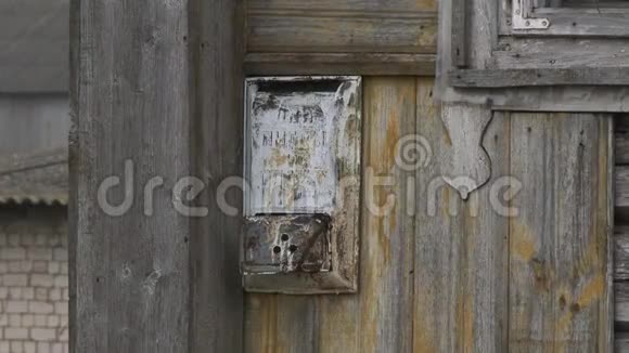 一个旧金属信箱挂在一所废弃的房子的边缘被时间和自然因素损坏的邮箱邮箱视频的预览图