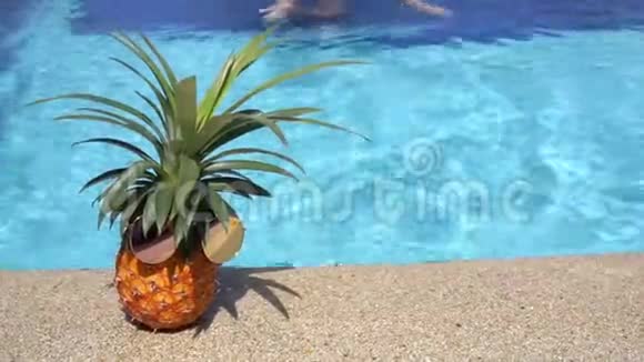 可爱的少女在泳池边戴着太阳镜游到菠萝旅行概念视频视频的预览图