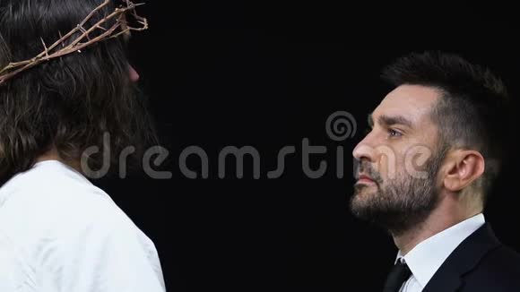 耶稣基督在黑暗的背景下拥抱哭泣的商人支持视频的预览图