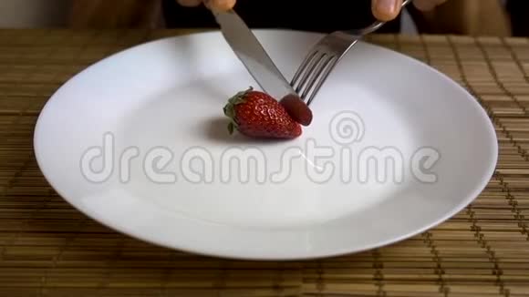 一个人用叉子和一把白色大盘子里的刀吃草莓视频的预览图