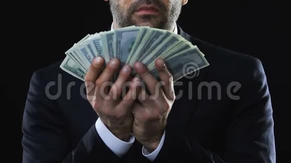 贪婪的商人用钞票抚摸着脸享受着财富视频的预览图