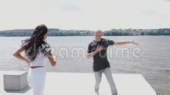 在湖边进行舞蹈训练的活跃情侣视频的预览图