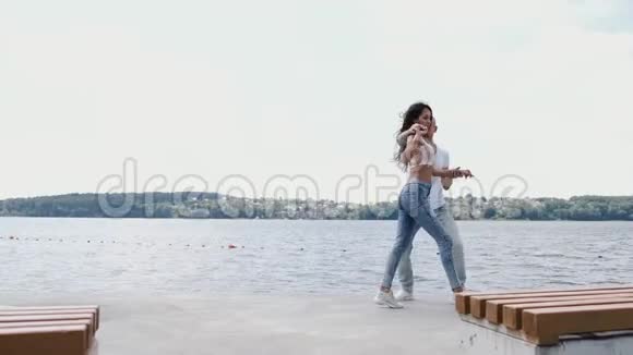 男人和女人在湖边跳舞和玩视频的预览图