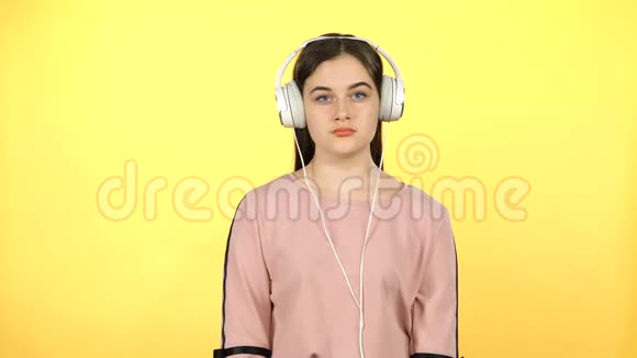 年轻女孩戴着大白耳机听音乐视频的预览图