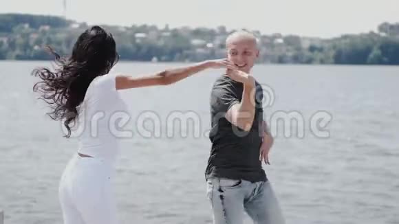 一位黑发女子和湖边的舞伴跳舞视频的预览图