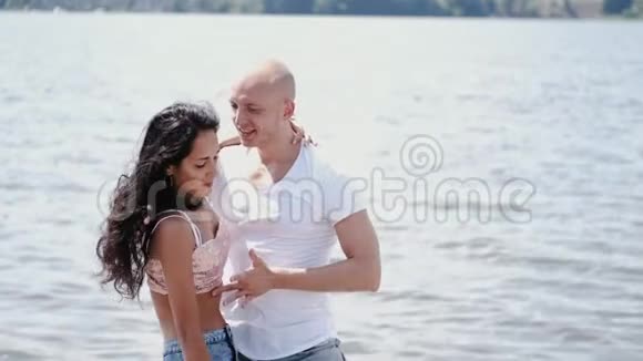 在湖边跳舞的秃头男人和黑发女人的特写镜头视频的预览图