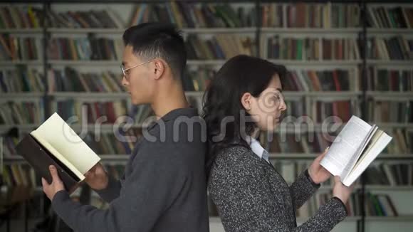 多民族夫妇背靠背在图书馆看书视频的预览图