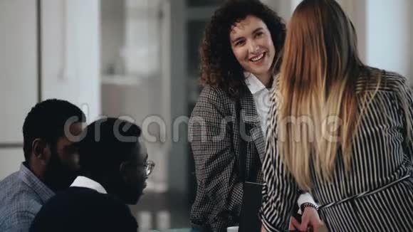 快乐的年轻多样化的商人在现代阁楼办公室开会美丽的欧洲微笑的女人和伴侣交谈视频的预览图