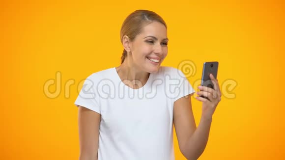 年轻开朗的女性使用智能手机应用程序持有美元钞票视频的预览图