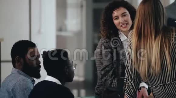 快乐的年轻多民族商业伙伴在现代办公室交谈有魅力的高加索女人和同事交谈视频的预览图