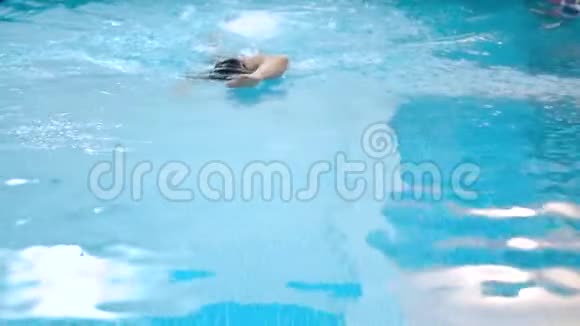 肌肉发达的人在游泳池里练习前爬行的慢动作视频的预览图