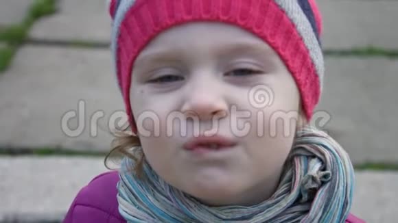 一个3到4岁的滑稽小女孩在户外做鬼脸慢动作视频的预览图