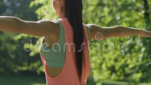 年轻女子在阳光公园做运动和伸展运动视频的预览图