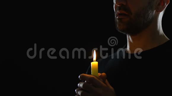 人拿着蜡烛在黑暗的背景下祈祷向上帝忏悔视频的预览图