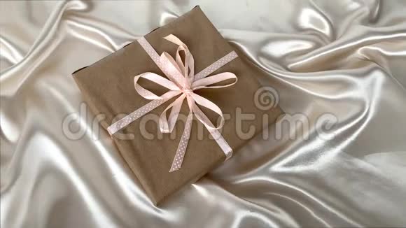 精美的白色丝绸织物上的手工纸上的礼物上面有小褶皱柔和流动奢华婚礼的概念视频的预览图